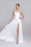 Strapless wedding dress with draped top and slit on the skirt.